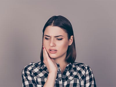 woman touching side of face